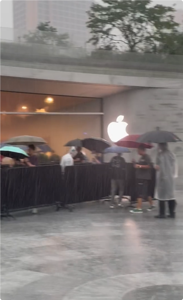 首批iPhone 16用户收到新机：果粉暴雨中在Apple Store排长队取货